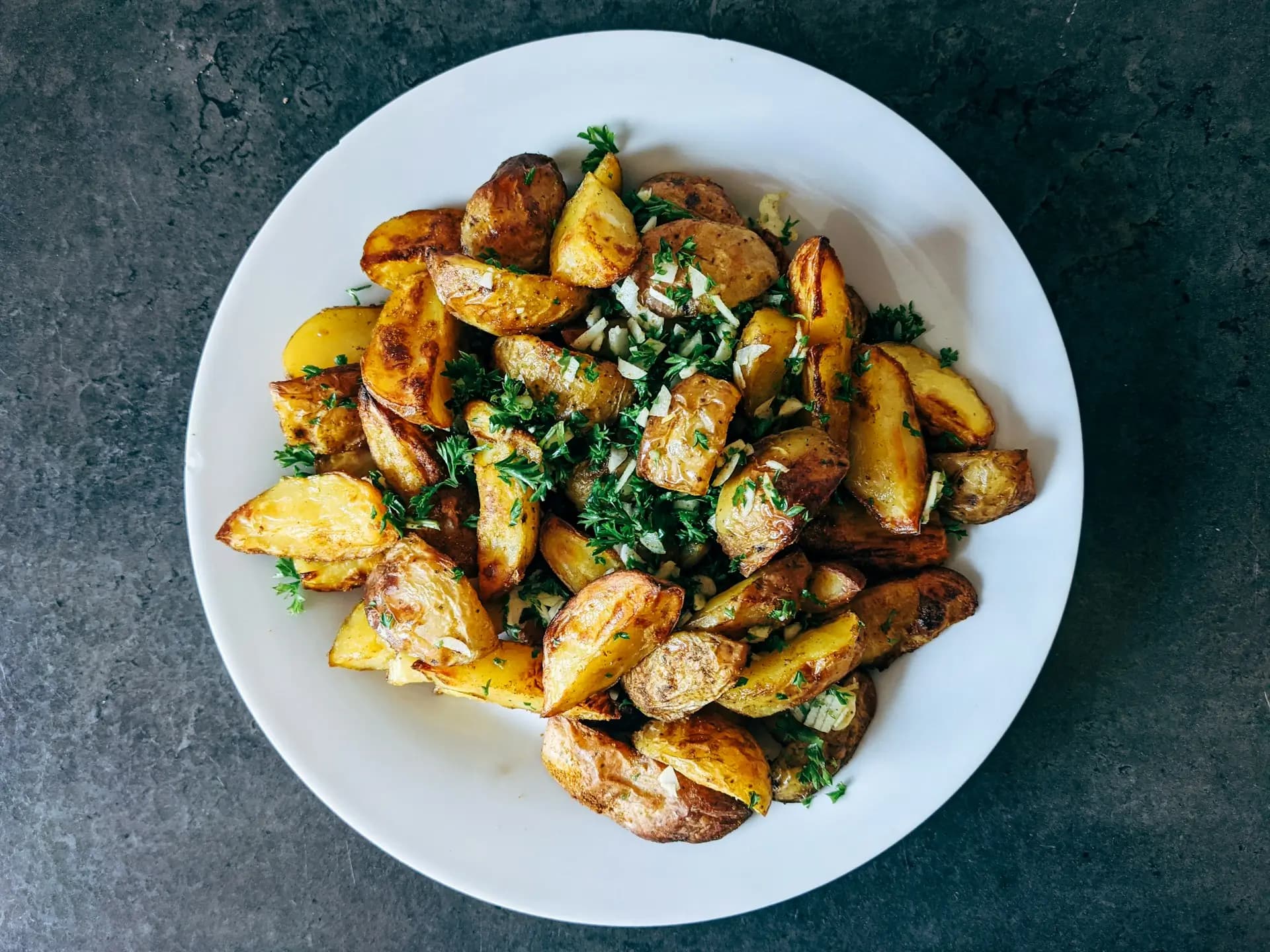 Piatto di patate, con erbe, cucinate al forno